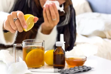 woman with a cold squeezing lemon in a cup