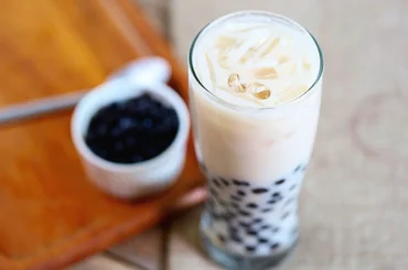 Coconut Milk Tea on a glass jar and a blurry bowl of tapioca pearls