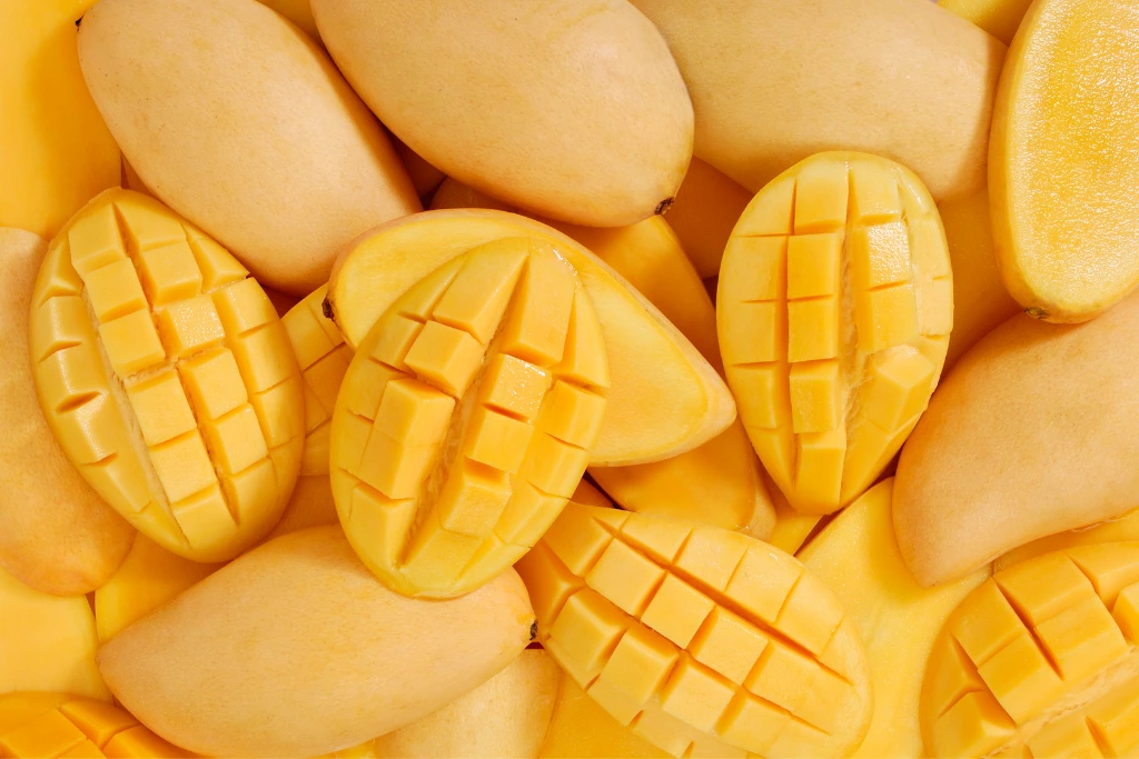 sliced mangoes on top of other mangoes