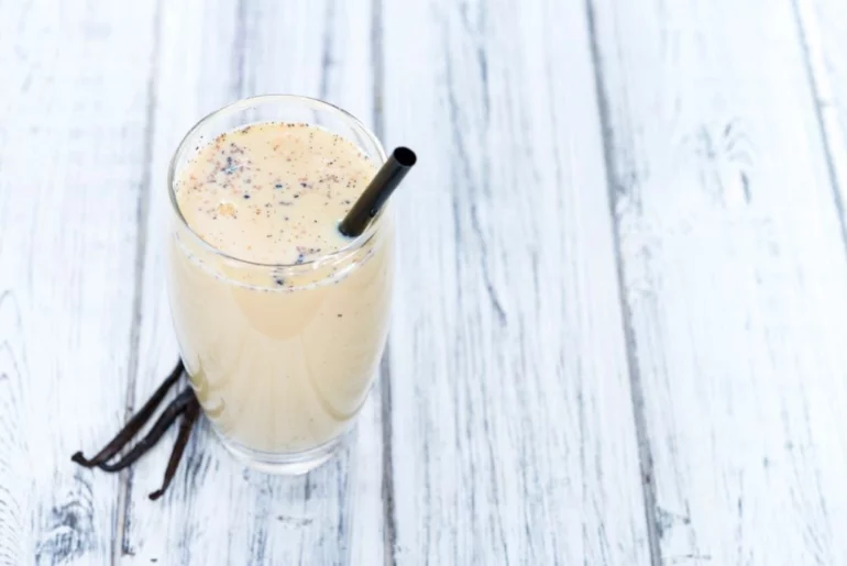 vanilla milk tea with vanilla seed pods on the table