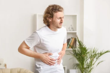 A man holding his stomach in a room