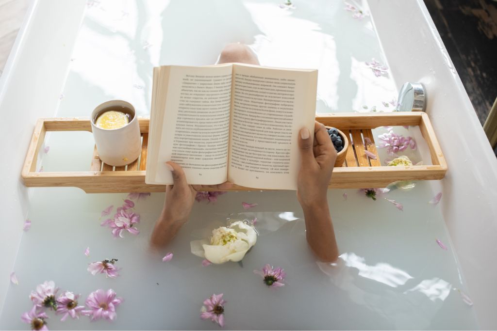 woman reading book while in bathtub