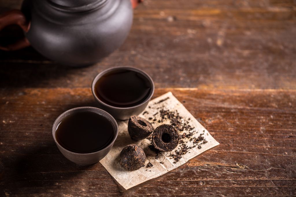 cups of pu erh tea placed in a wooden table