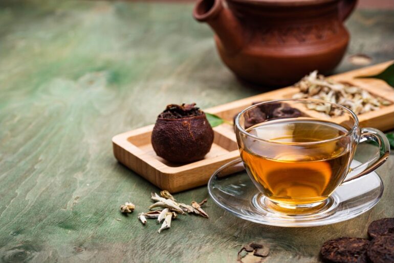 A cup of pu erh tea with teapot background