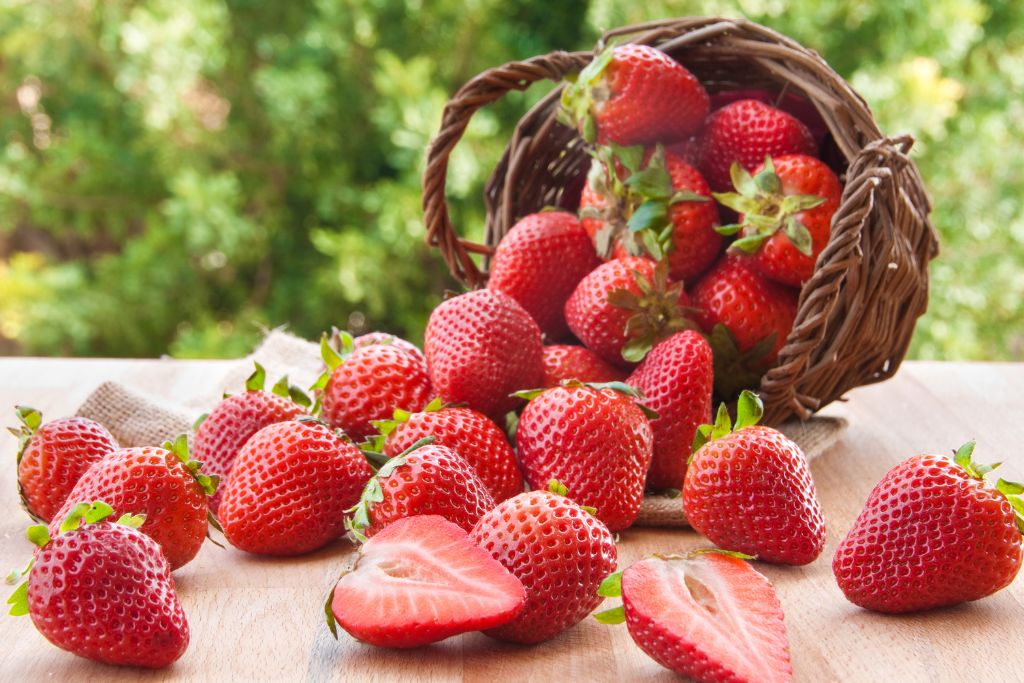 strawberries on wood string basket on a blurred nature background