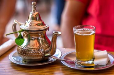 Moroccan mint tea served in a glass together with a silver kettle