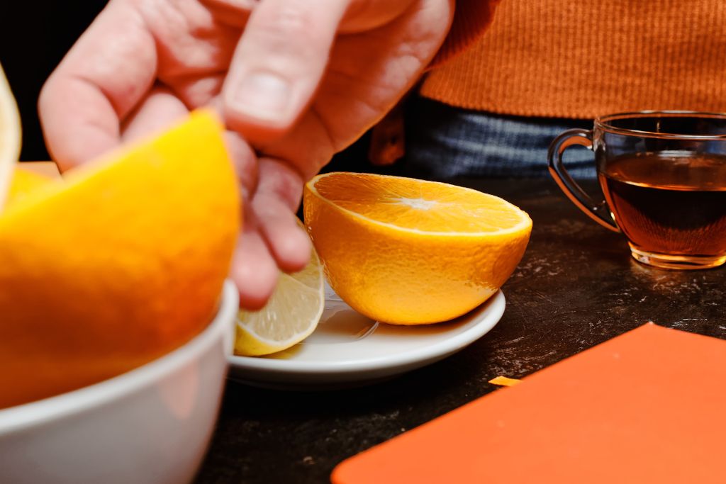 orange slices on small white plate together with a cup of tea