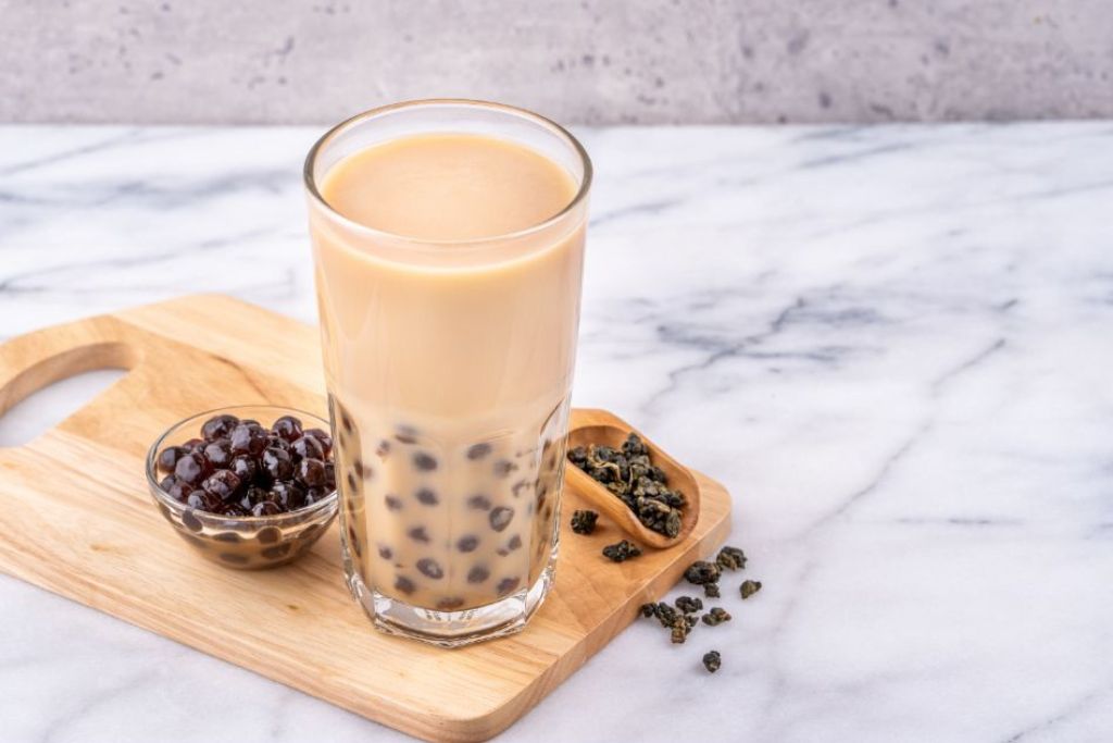 boba milk tea with tapioca pearls on a wooden chopping board