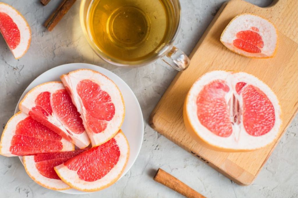 a cup of tea with sliced grapefruit on the side
