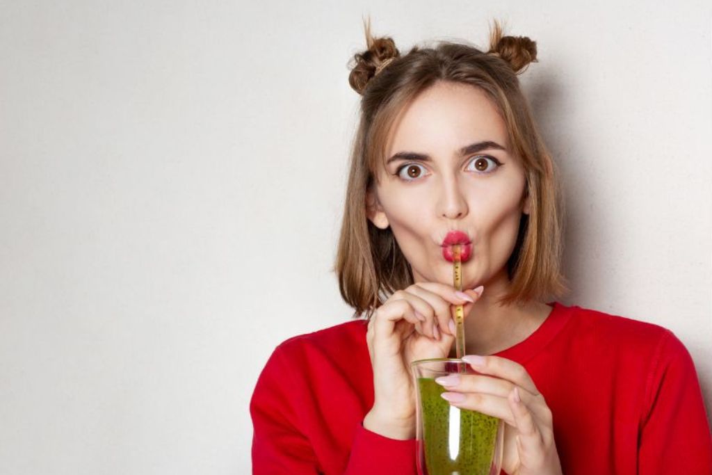 a funny girl drinking kiwi