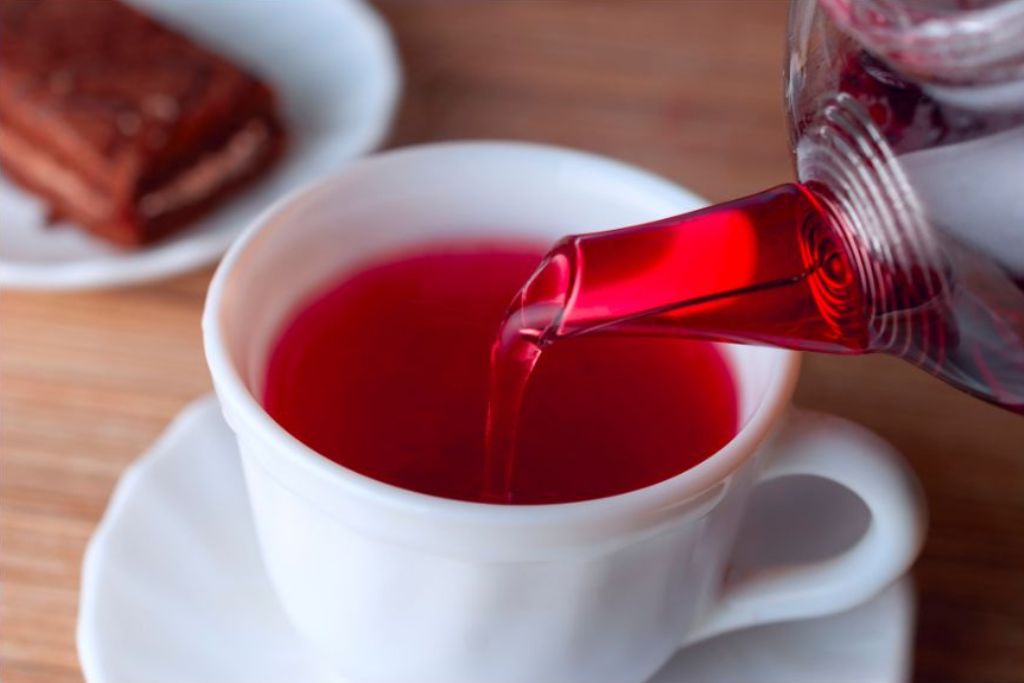 pouring hibiscus tea from kettle